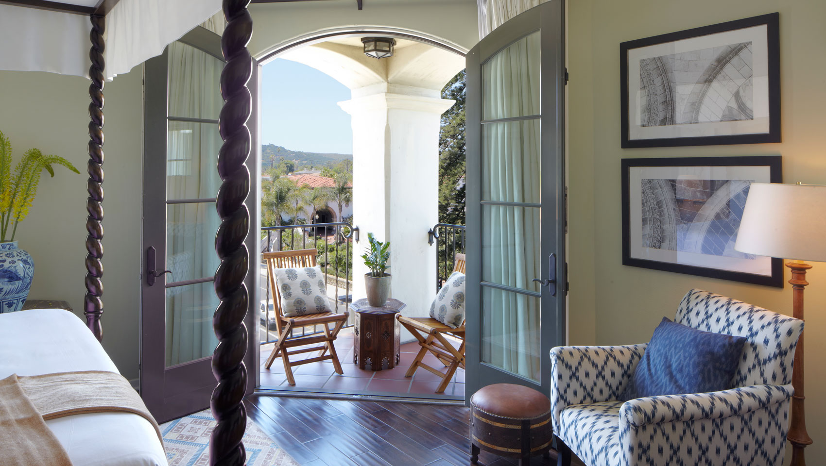 king bedded guest room with open balcony doors overlooking downtown