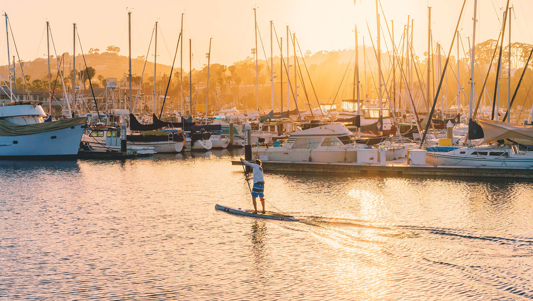 man paddle boarding at sunset