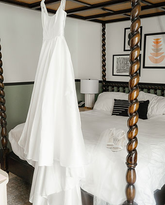 wedding dress hanging on bed canopy