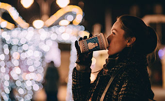 a person drinking from a holiday cup