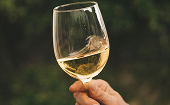 Hand swirling white wine in glass
